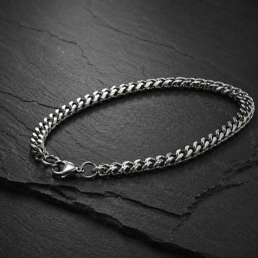 Silberfarbenes Herren Armband aus Edelstahl mit Karabinerverschluss auf dunkler Schieferplatte.