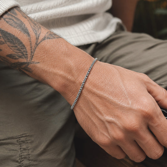 Feines Venezianer Herren Armband aus Edelstahl am tätowierten Handgelenk getragen.