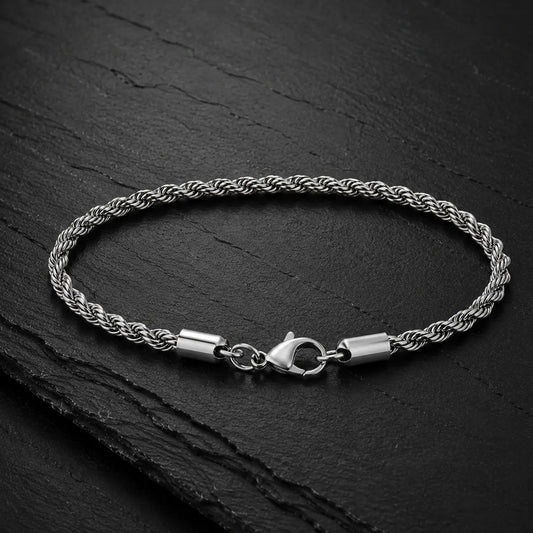 Herren Armband im Kordeldesign aus silberfarbenem Edelstahl auf dunkler Schieferplatte.