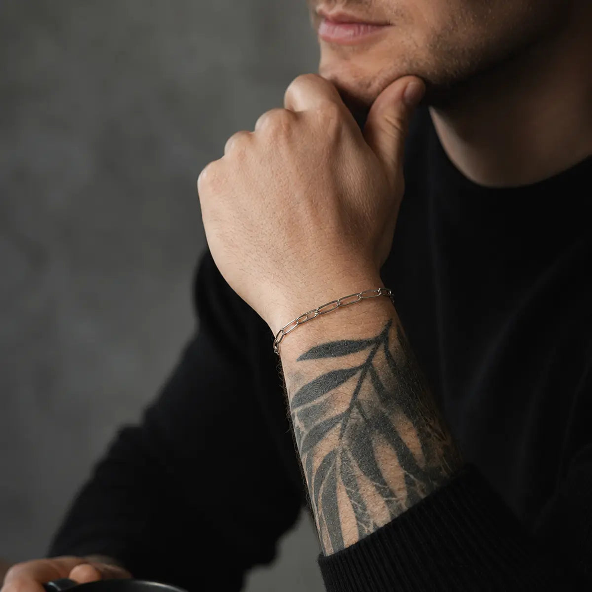 Feines Paperclip Herren Armband aus Edelstahl am tätowierten Handgelenk getragen.