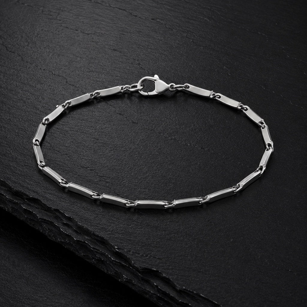 Facettiertes Herren Armband aus Edelstahl auf dunkler Schieferplatte.