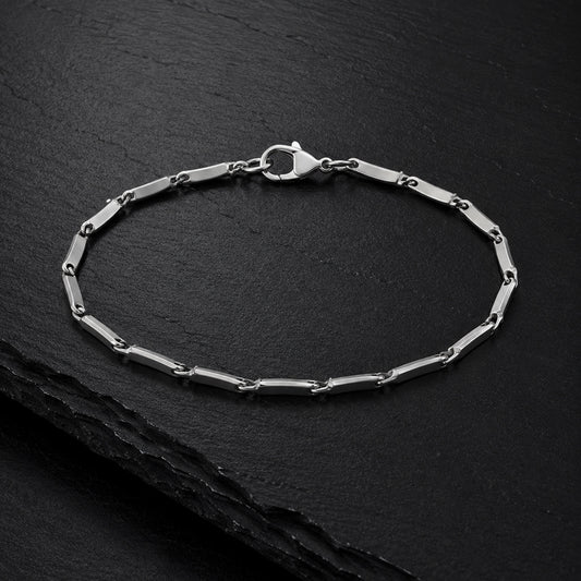 Facettiertes Herren Armband aus Edelstahl auf dunkler Schieferplatte.