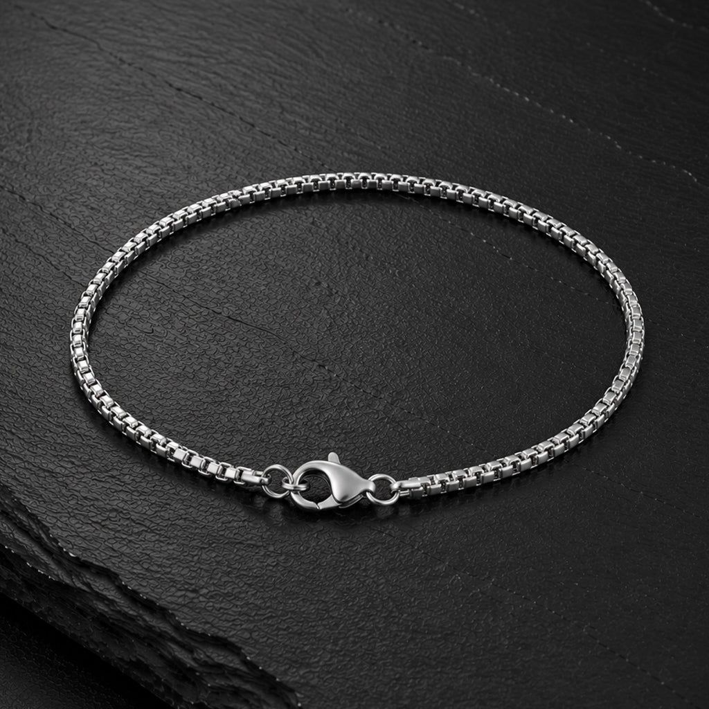 Feines Venezianer Herren Armband aus Edelstahl auf dunkler Schieferplatte.