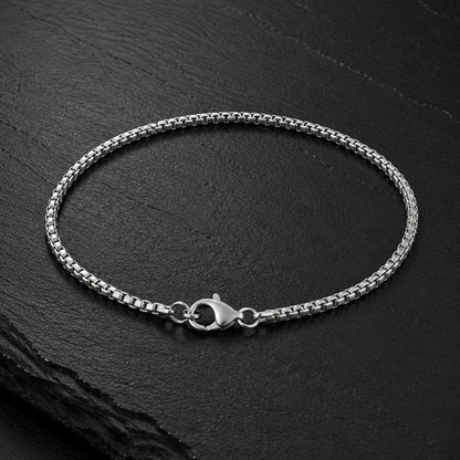 Feines Venezianer Herren Armband aus Edelstahl auf dunkler Schieferplatte.