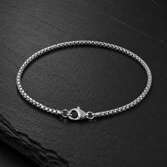 Feines Venezianer Herren Armband aus Edelstahl auf dunkler Schieferplatte.