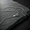 Halskette auf einem Schieferstein. Kette aus 925 Silber. Ankerkette