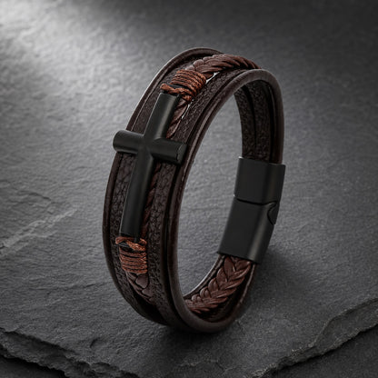 Lederarmband mehrreihig in braun mit schwarzem Kreuz aus Edelstahl auf Schieferplatte