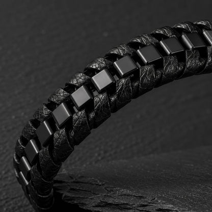 Schwarzes Herren Lederarmband mit geflochtenem Design und Edelstahlelementen in Detailaufnahme.