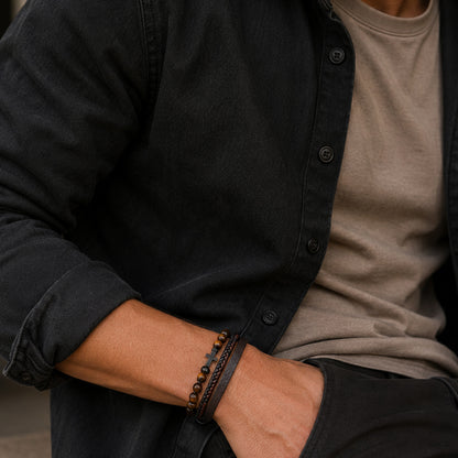 Herren Lederarmband schwarz-braun mit Tigerauge Perlen und Kreuz getragen am Handgelenk.