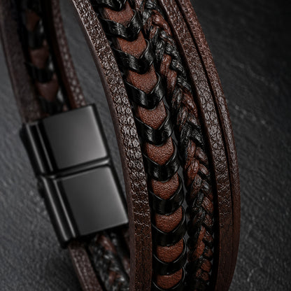 Detailaufnahme eines schwarz-braunen Herren Lederarmbands mit geflochtenen Strängen.