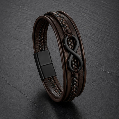 Lederarmband in braun für Männer mit 5 Strängen geflochten und glatt und mit Infinite Zeichen aus schwarzem Edelstahl auf einer Schieferplatte