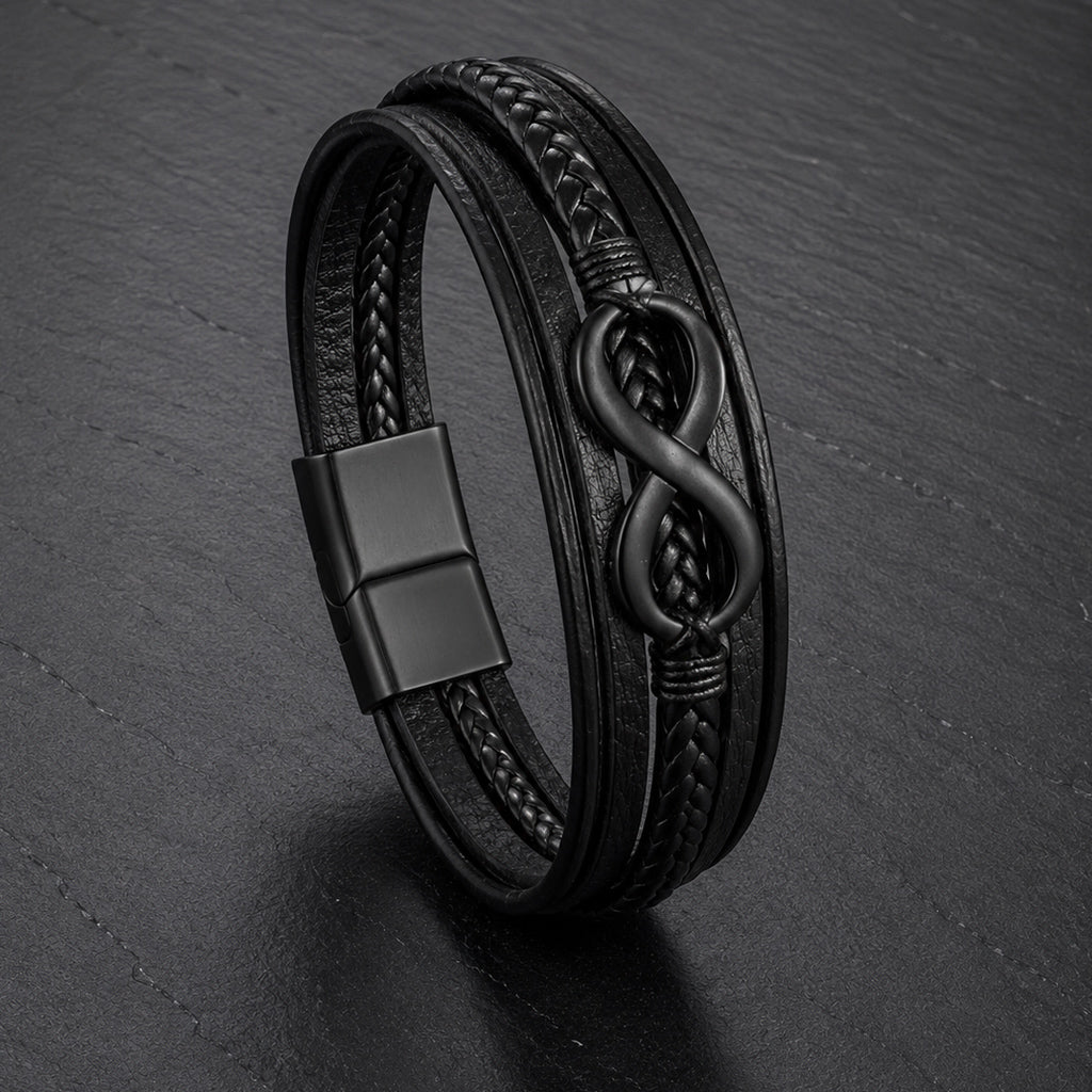 Lederarmband in schwarz für Männer mit 5 Strängen geflochten und glatt und mit Infinite Zeichen aus schwarzem Edelstahl auf einer Schieferplatte