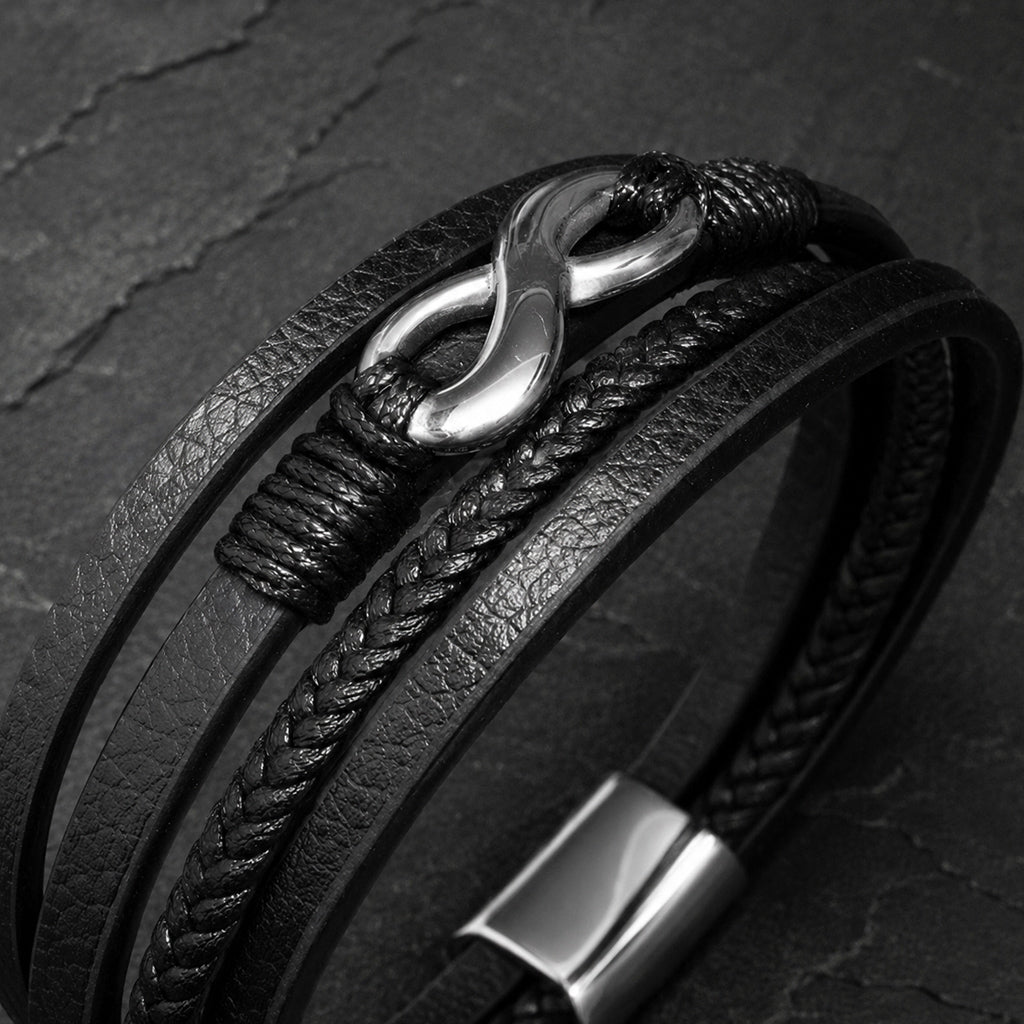 Mehrsträngiges schwarzes Herren Lederarmband mit Infinity Symbol in Detailaufnahme.