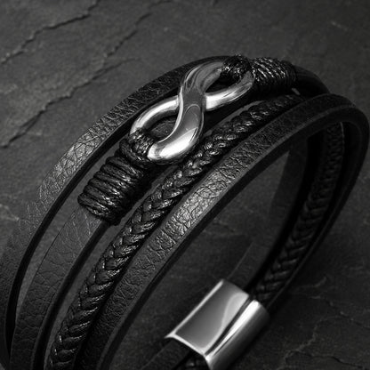 Mehrsträngiges schwarzes Herren Lederarmband mit Infinity Symbol in Detailaufnahme.