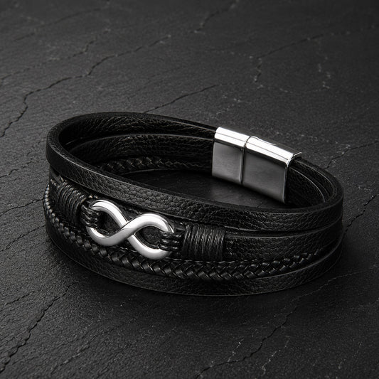 Mehrsträngiges schwarzes Herren Lederarmband mit Infinity Symbol auf Schieferplatte.
