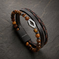 Lederarmband mehrreihig in schwarz mit Tigerauge Perlen und Raute aus silbernem Edelstahl auf Schieferplatte