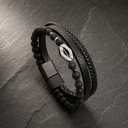 Lederarmband mehrreihig in schwarz mit  schwarzen Perlen aus Lavastein und Raute aus silbernem Edelstahl auf Schieferplatte